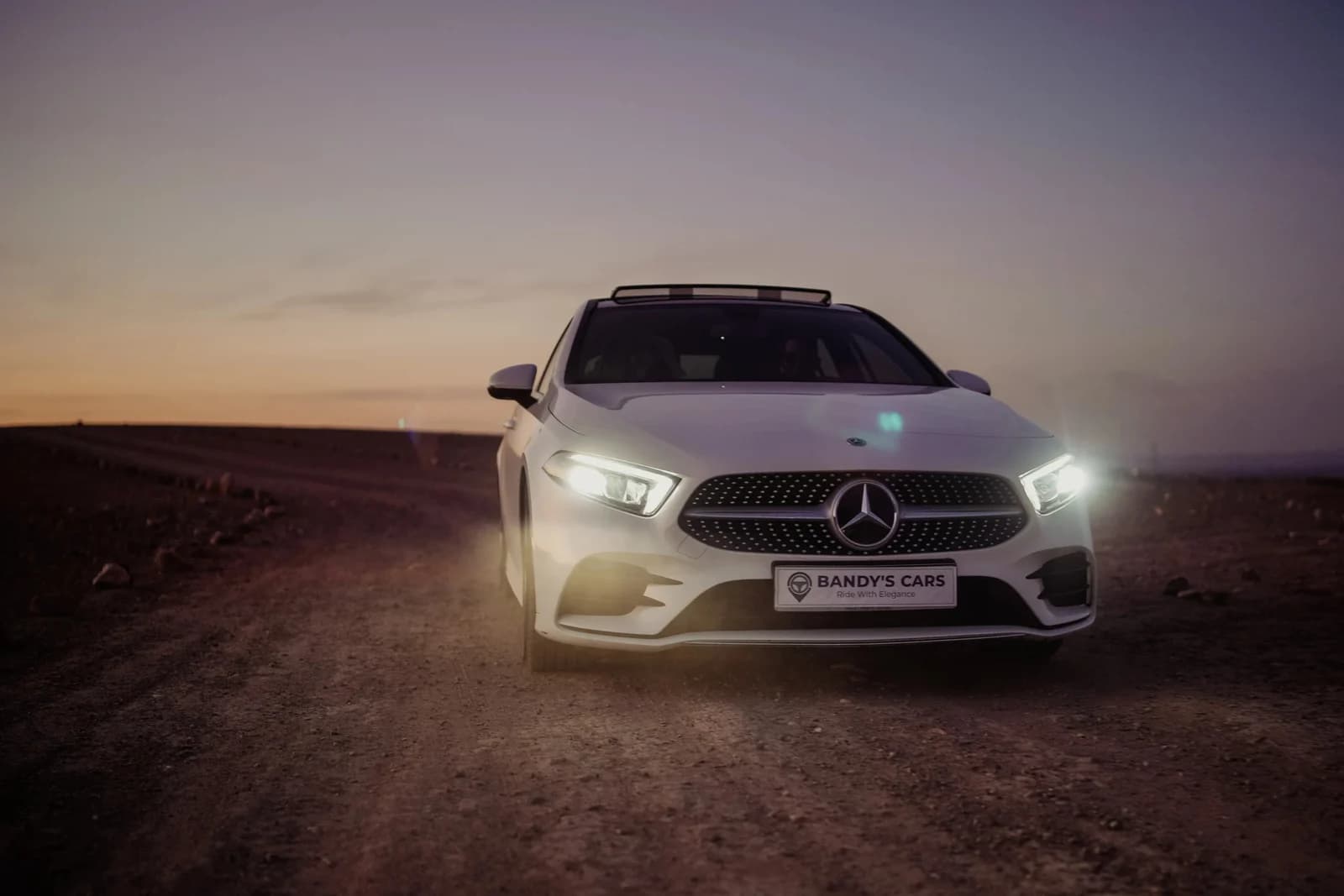 A white Mercedes from Bandy’s Cars, photographed at dusk